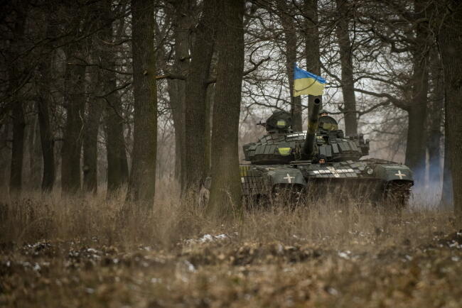 Ukraiński czołg T-72 manewruje wśród drzew w obwodzie donieckim we wschodniej Ukrainie. / autor: PAP/EPA/OLEG PETRASYUK