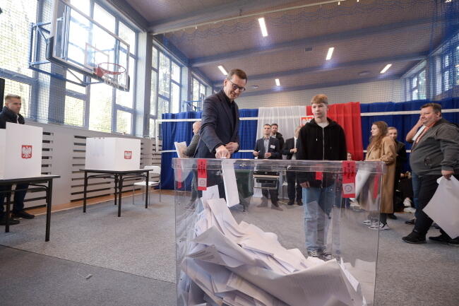 . Premier Mateusz Morawiecki (C-L) oddał głos w lokalu wyborczym przy ulicy Spartańskiej w Warszawie / autor: PAP/Marcin Obara