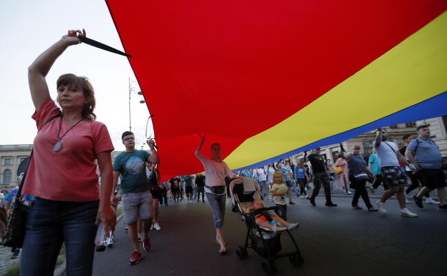 Demonstranci, którzy pojawili się w sobotę na ulicach Bukaresztu nieśli flagi Rumunii / autor: PAP/EPA/Robert Ghement