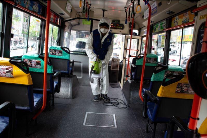 Pracownik rozpyla środek dezynfekujący, jako środek zapobiegający pandemii w autobusach w Seulu. / autor: PAP/EPA/JEON HEON-KYUN