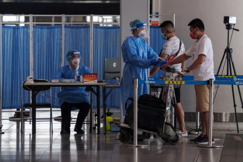 Pracownicy ochrony lotniska sprawdzający temperaturę pasażerów na terminalu 3 międzynarodowego lotniska w Pekinie / autor: PAP/EPA/STRINGER