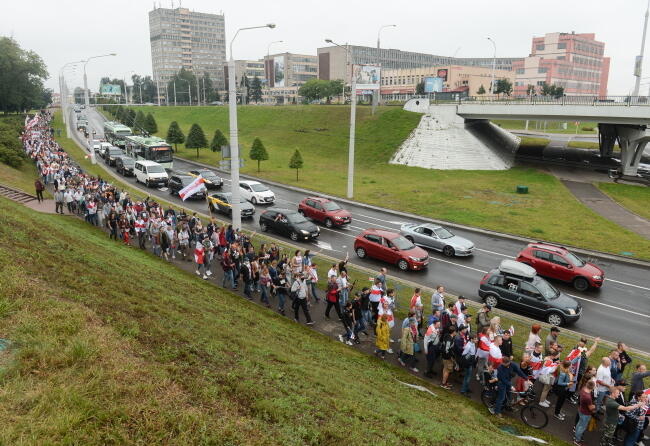 Kolumna maszerujących w kierunku centrum robotników z fabryk w Mińsku / autor: PAP/EPA/YAUHEN YERCHAK