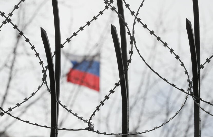 Rosyjska flaga za drutem kolczastym na ogrodzeniu ambasady rosyjskiej / autor: PAP/EPA/SERGEY DOLZHENKO