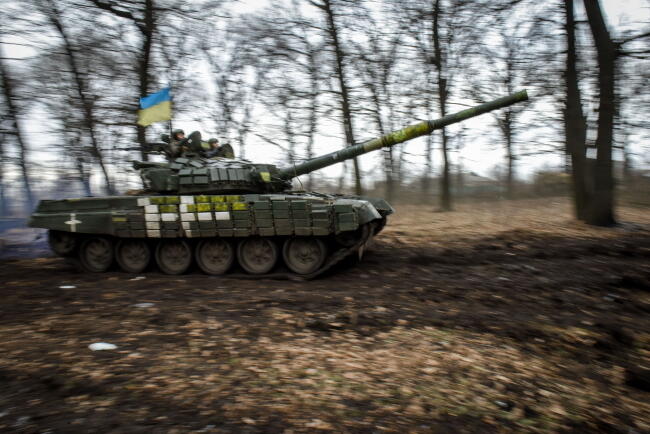 Ukraiński czołg T-72 manewruje między drzewami w obwodzie donieckim we wschodniej Ukrainie. / autor: PAP/EPA/OLEG PETRASIUK
