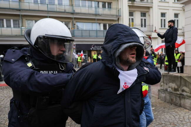 Policjanci z zatrzymanym demonstrantem / autor: PAP/Paweł Supernak