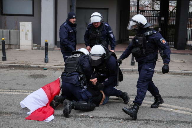 Moment zatrzymania przez policjantów demonstranta z flagą / autor: PAP/Paweł Supernak
