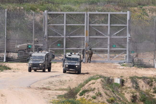 Izraelskie pojazdy wojskowe przy ogrodzeniu na granicy ze Strefą Gazy / autor: PAP/EPA/ABIR SULTAN